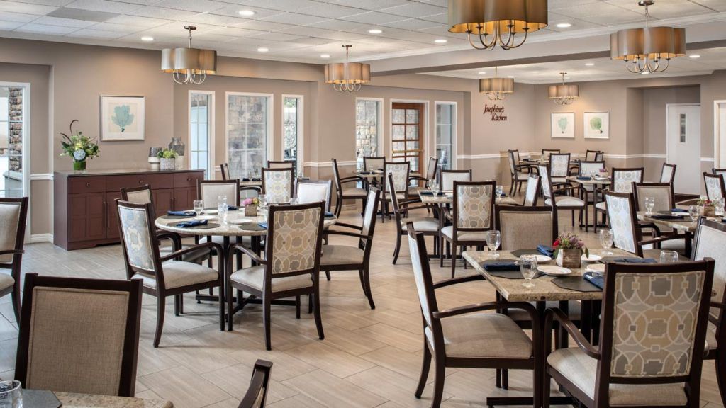 Interior view of Belmont Village Senior Living in Cardiff By The Sea featuring dining area and art.