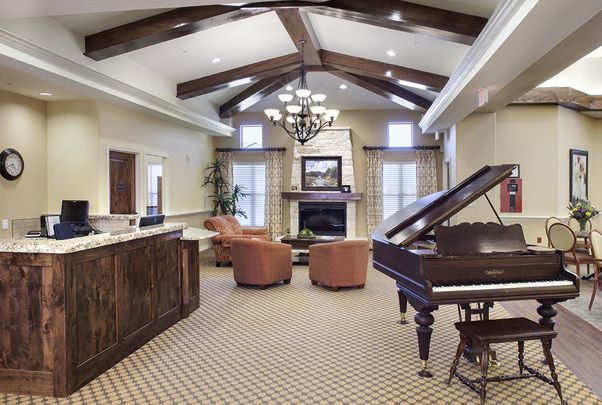 Interior view of The Auberge At Onion Creek senior living community featuring grand piano and elegant decor.