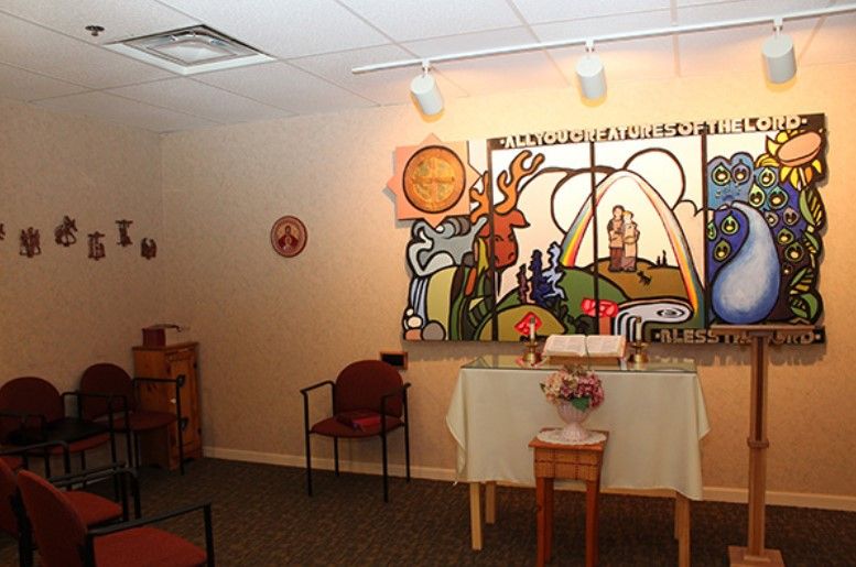 Senior residents enjoying a meal in the dining room of MainStreet Lodge with church-inspired decor.