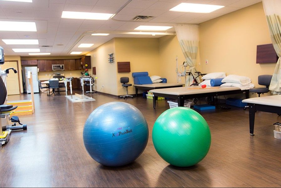 Seniors working out in MainStreet Lodge's fitness area with modern appliances and comfortable furniture.