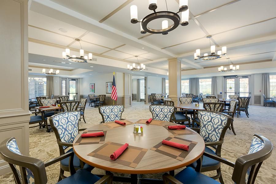 Architectural view of Las Palomas Senior Living community featuring dining room with elegant furniture.