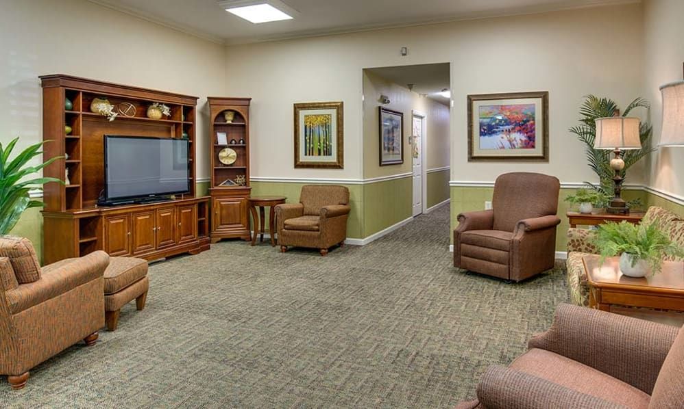 Senior living room at Auburn Creek with art, plants, modern electronics, and cozy furniture.