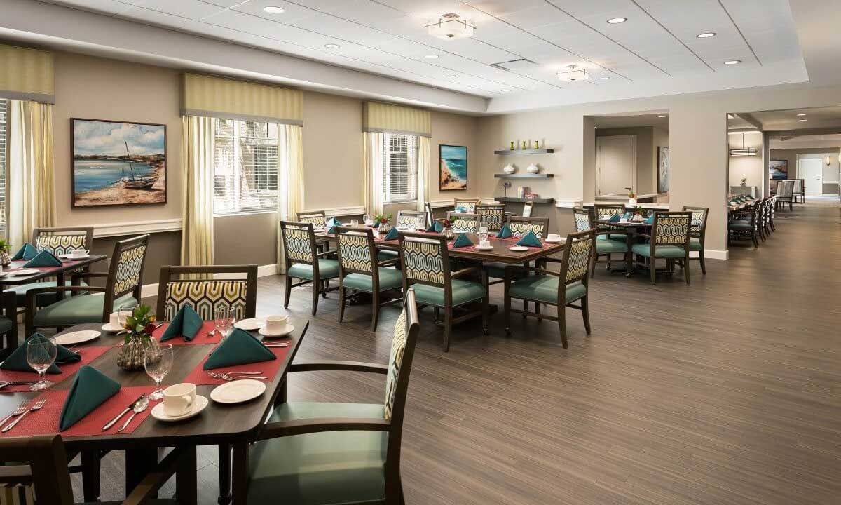 Interior view of HarborChase of Wellington Crossing senior living community featuring dining room and lounge.