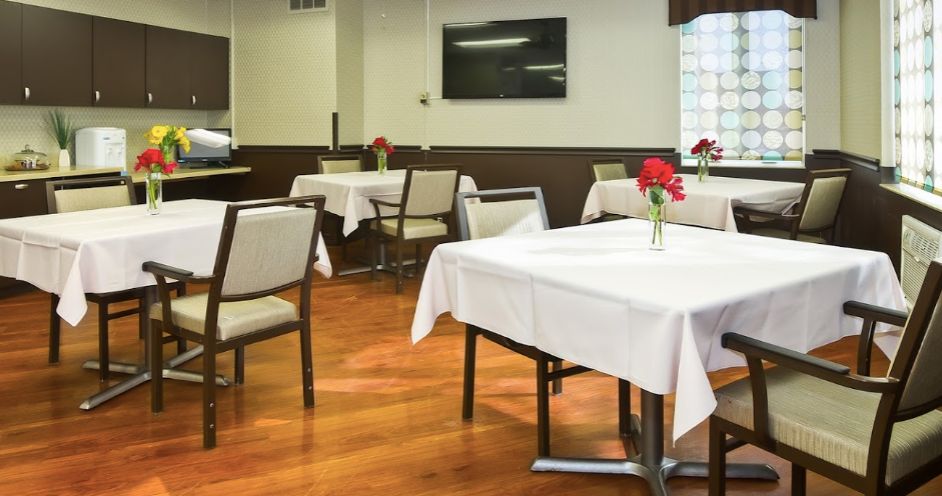 Interior view of Aperion Care Burbank senior living community dining room with modern decor.