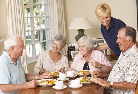 Seniors enjoying a brunch at Richland Place Senior Living Center, laughing and dining together.