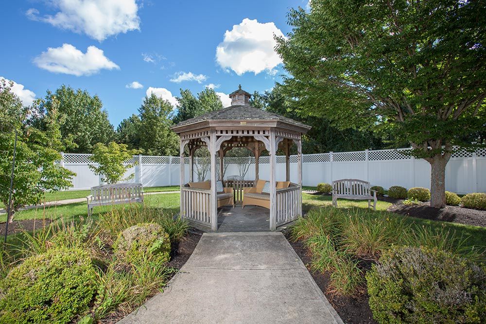 Outdoor and indoor view of The Atrium at Veronica Drive senior living community with garden and gazebo.
