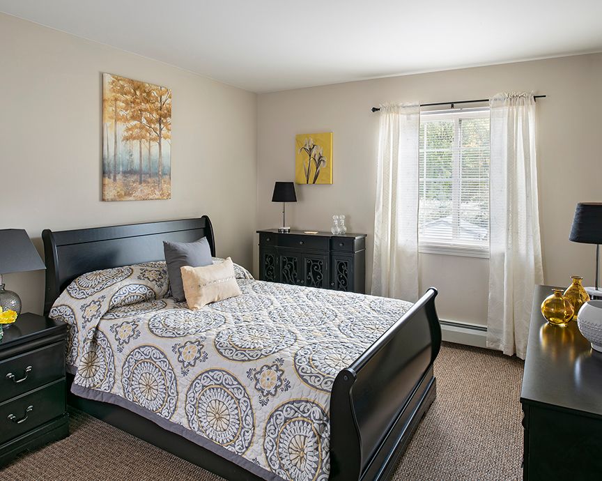 Interior view of a bedroom in American House Southgate senior living community with elegant decor.