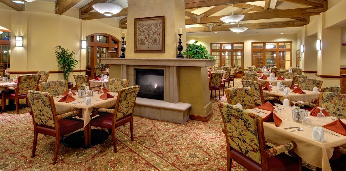 Interior view of La Vida Del Mar senior living community featuring dining room, reception area, and decor.