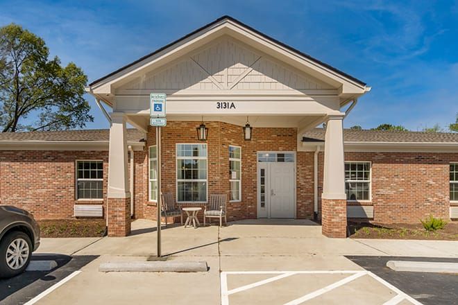 Architectural view of Brookdale Jackson Oaks senior living community with housing, furniture, and portico.