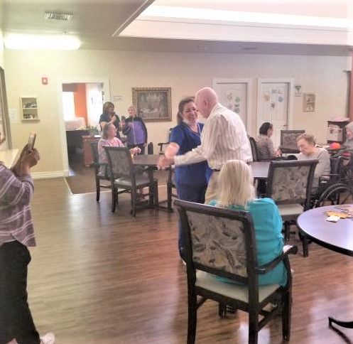 Senior residents enjoying a meal in the dining room of Barton House, a well-furnished senior living community.