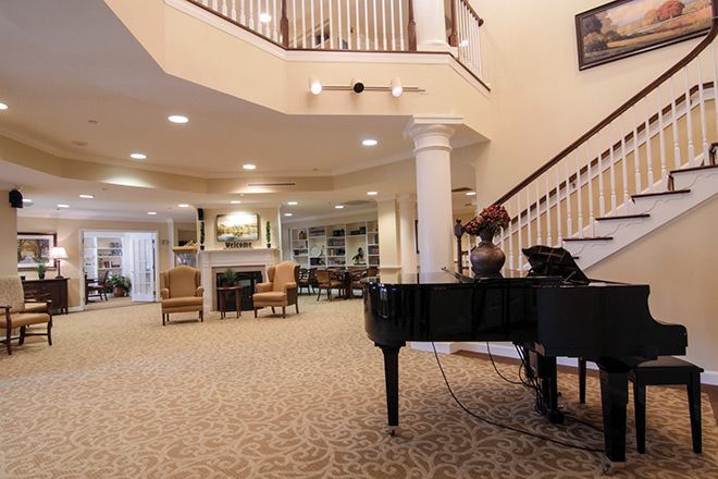 Senior resident playing grand piano in the foyer of Brookdale Lake Ridge senior living community.
