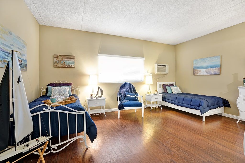 Interior view of a well-furnished bedroom at Arbor Palms Senior Living Community in Anaheim.