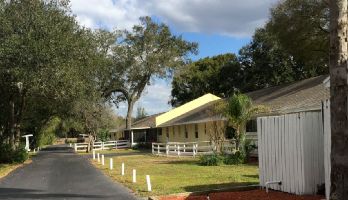 Angels Senior Living community in North Tampa, showcasing rural architecture, lush trees, and serene outdoors.