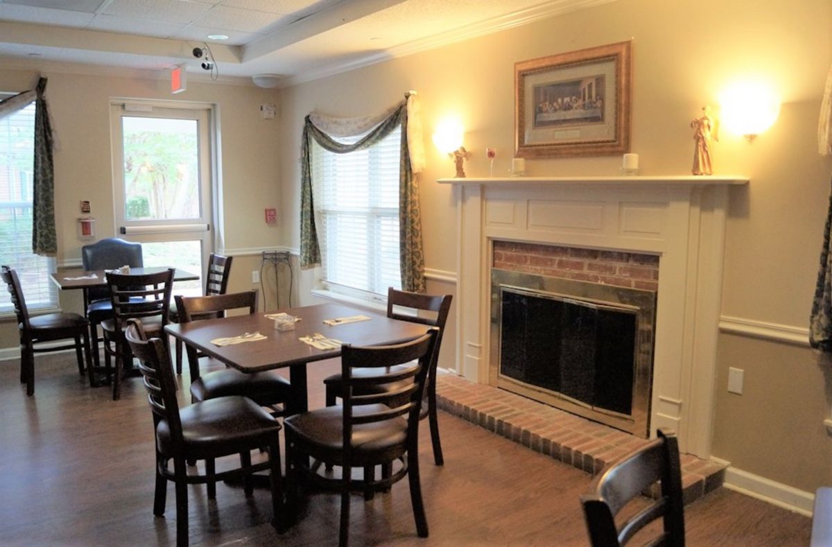 Senior living community Cleveland House featuring elegant dining room with fireplace and decor.