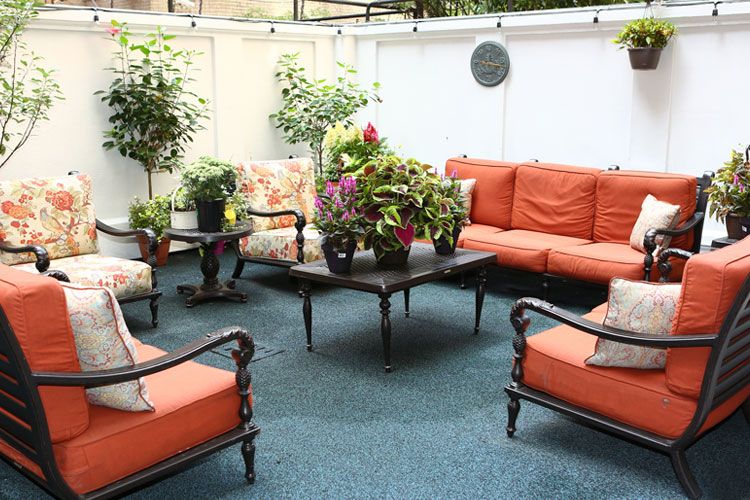 Senior living community lounge at 80th Street Residence with stylish furniture and potted plants.
