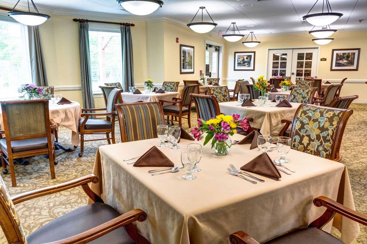 Interior view of Auberge At Naperville senior living community featuring dining room with elegant furniture.