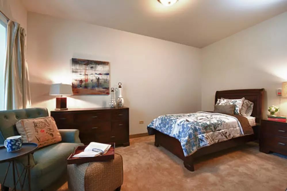 Interior design of a bedroom at Oak Hill Supportive Living Community with art, furniture, and decor.