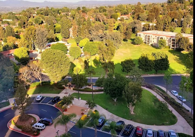 Aerial view of Towers at Laguna Woods Village senior living community with buildings and cars.