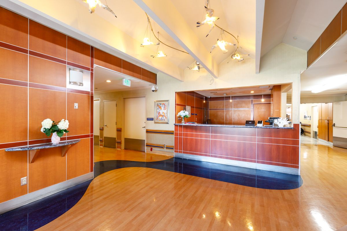 Senior living community reception area at Ocean Pointe Healthcare Center with hardwood flooring.