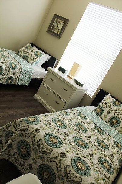 Senior living community bedroom at Accuro Homes II, featuring comfortable bed and home decor.
