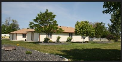Grass and trees surround the villa-style senior living community, Home Sweet Home Care.