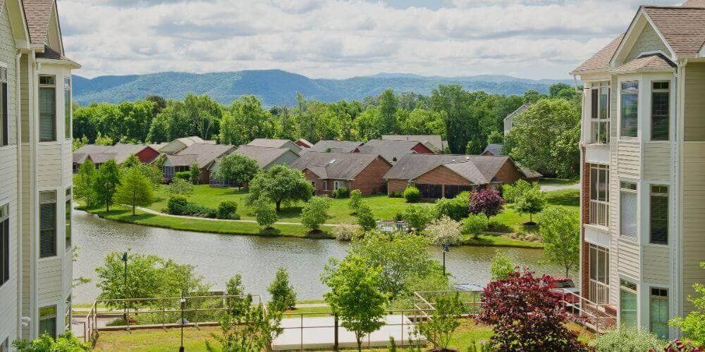 Scenic view of Asbury Place Maryville senior living community with lakefront, buildings, and greenery.