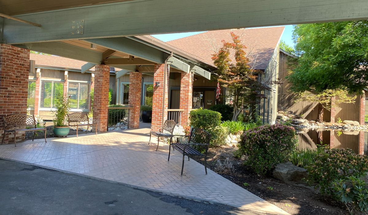 Senior living community, Pacifica Citrus Heights, featuring patio, porch, and lush backyard.