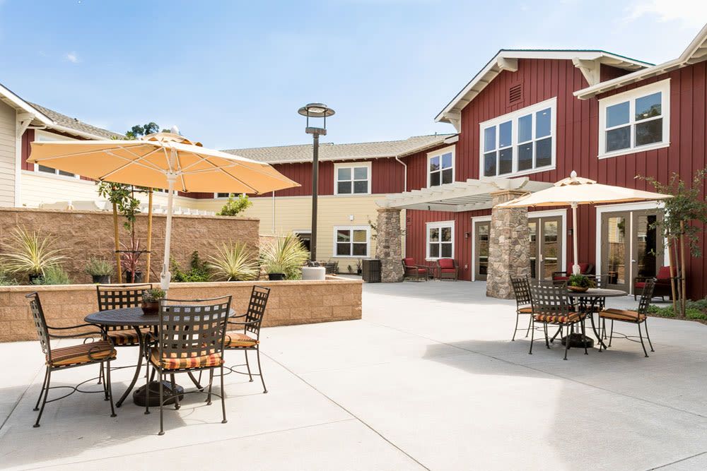 Senior living community Mariposa at Ellwood Shores featuring modern architecture, indoor furniture, and outdoor patio.