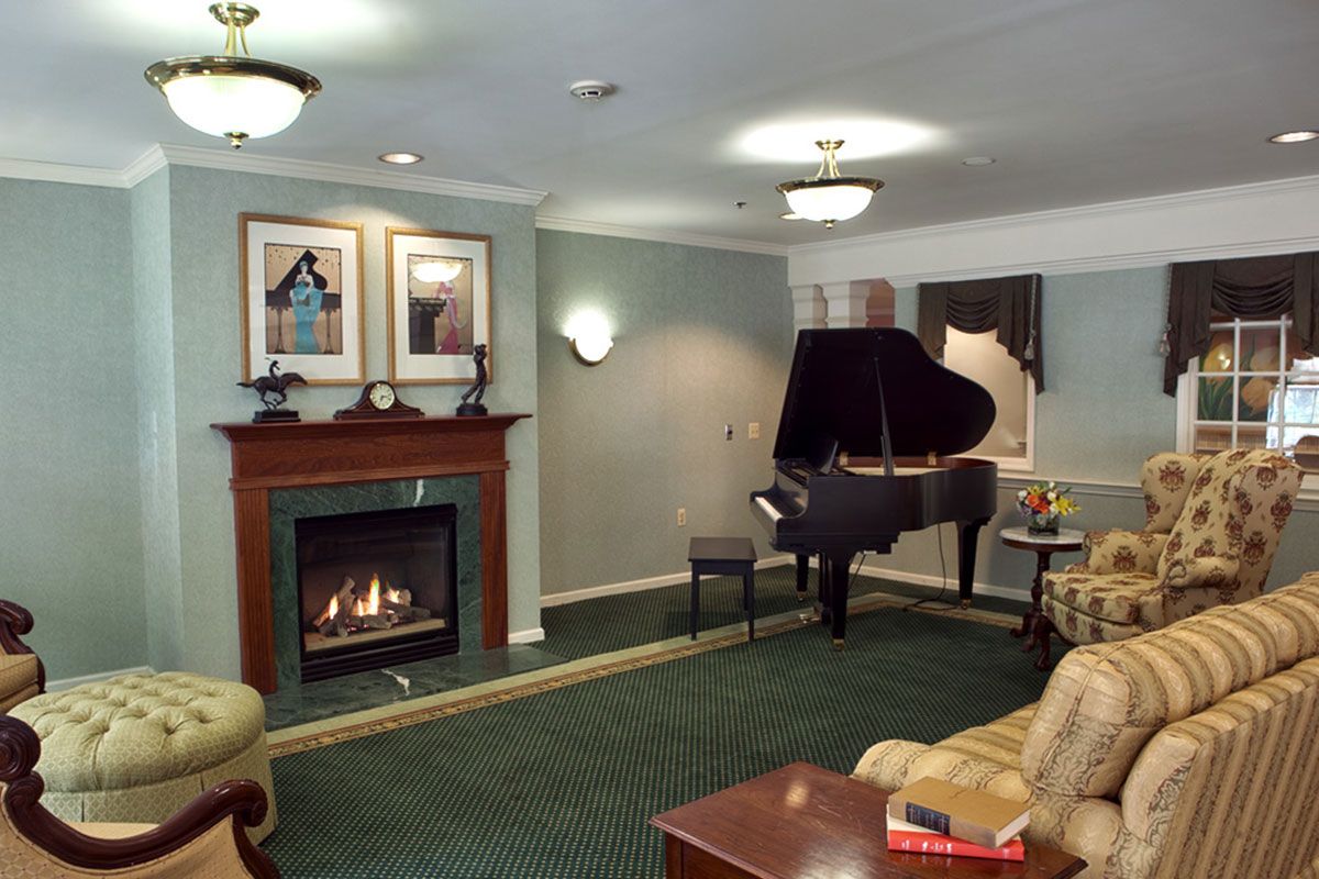 Senior playing piano in the cozy living room of Brandywine Living at Middlebrook Crossing.