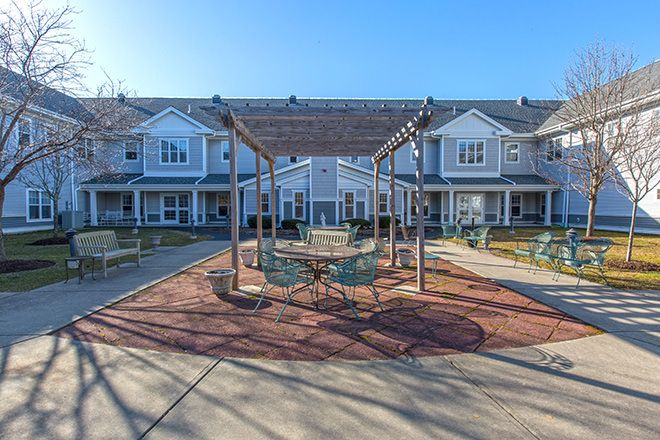 Brookdale Cape Cod senior living community featuring houses, patio furniture, and dining tables.