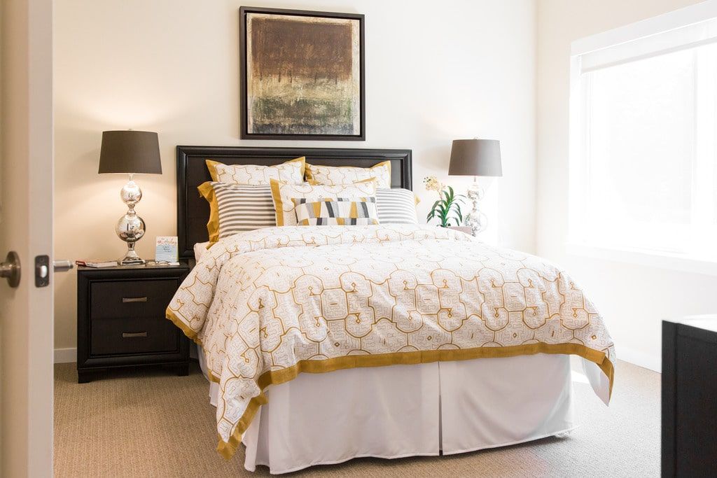 Interior design of a bedroom at Aegis Living San Rafael with art, furniture, and home decor.