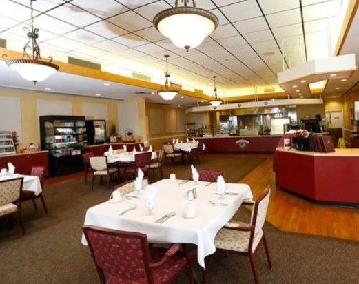 Indoor view of Sunnyside senior living community featuring dining area, cafe, and modern architecture.