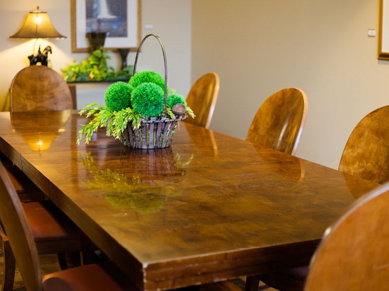 Elegant dining room at Cordia Senior Living with wooden furniture, indoor plants, and flower arrangements.