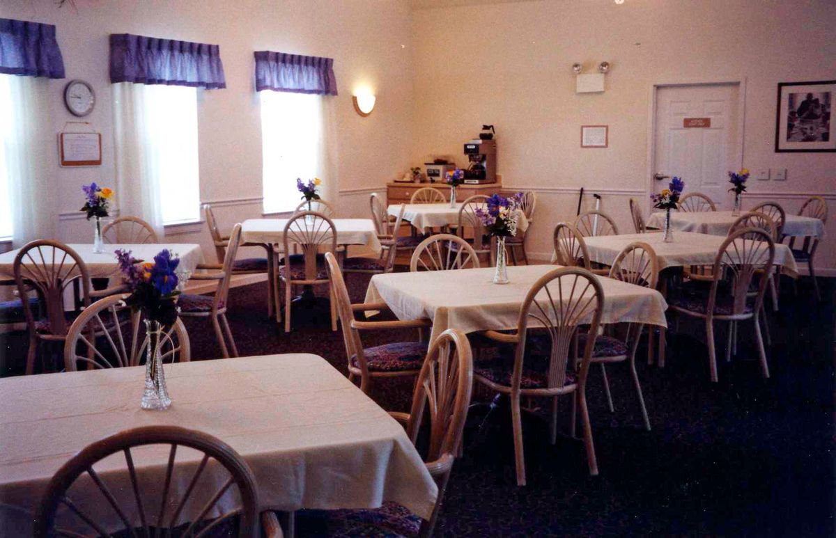 Seniors dining in St. Andrews Assisted Living community with well-furnished interiors.