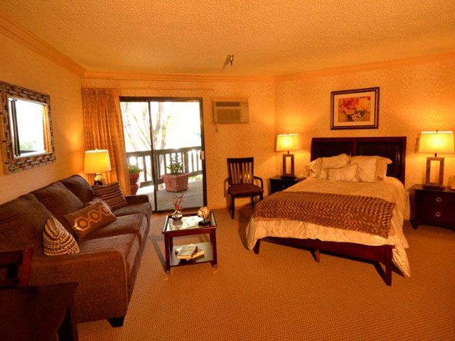 Seniors enjoying modern amenities in Huntington Retirement Hotel's furnished rooms with electronics.