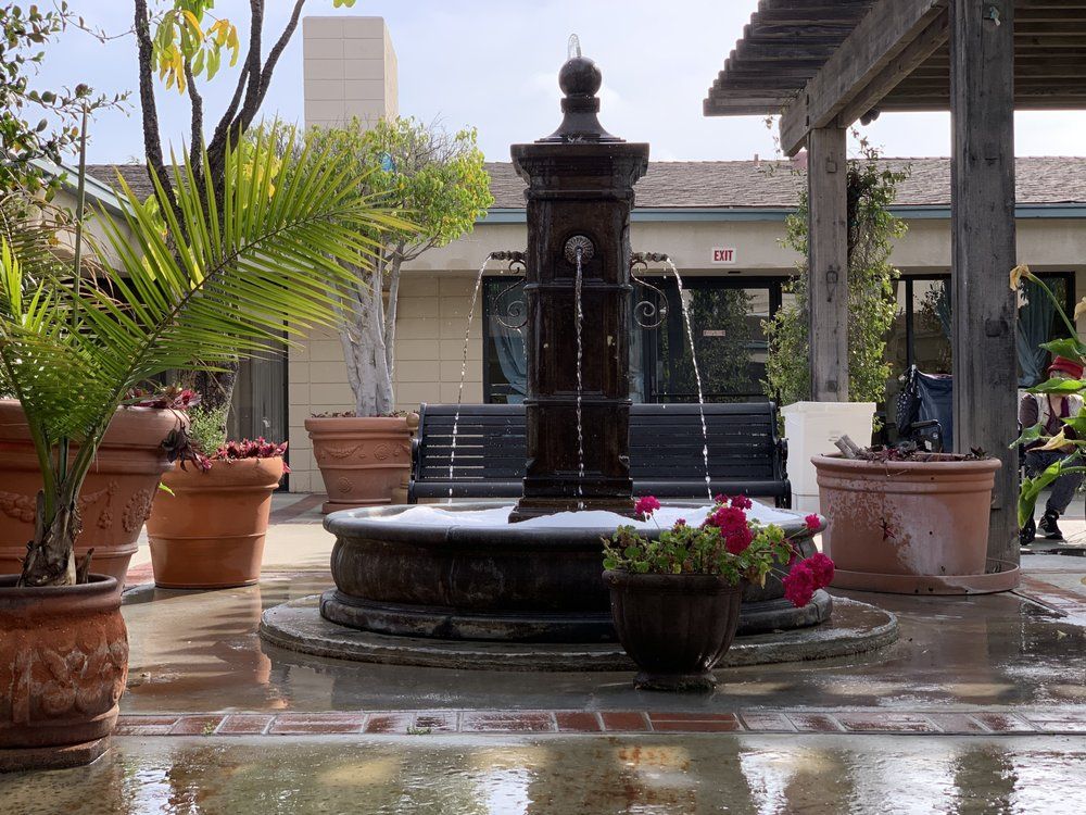 Senior living community at Alhambra Healthcare & Wellness Center with architecture, fountain, and plants.