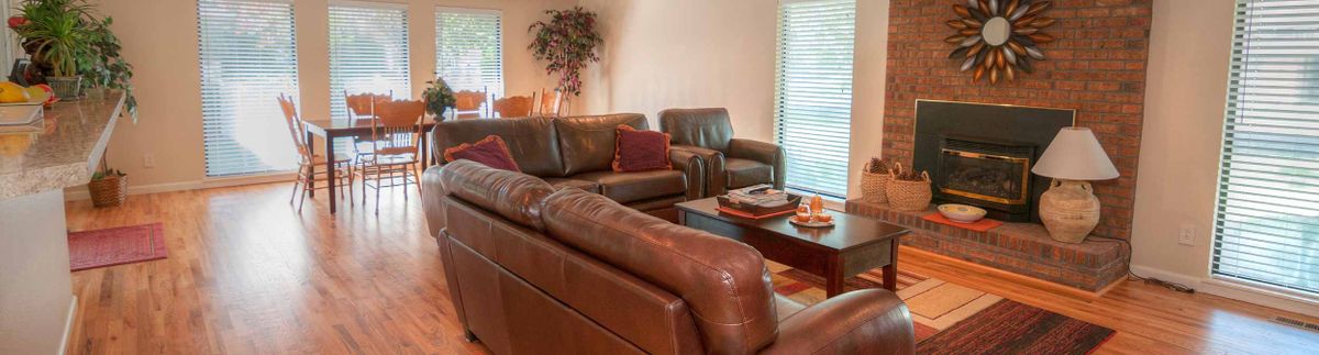 Interior view of Poppy Fields Assisted Living featuring a cozy living room with hardwood furniture.