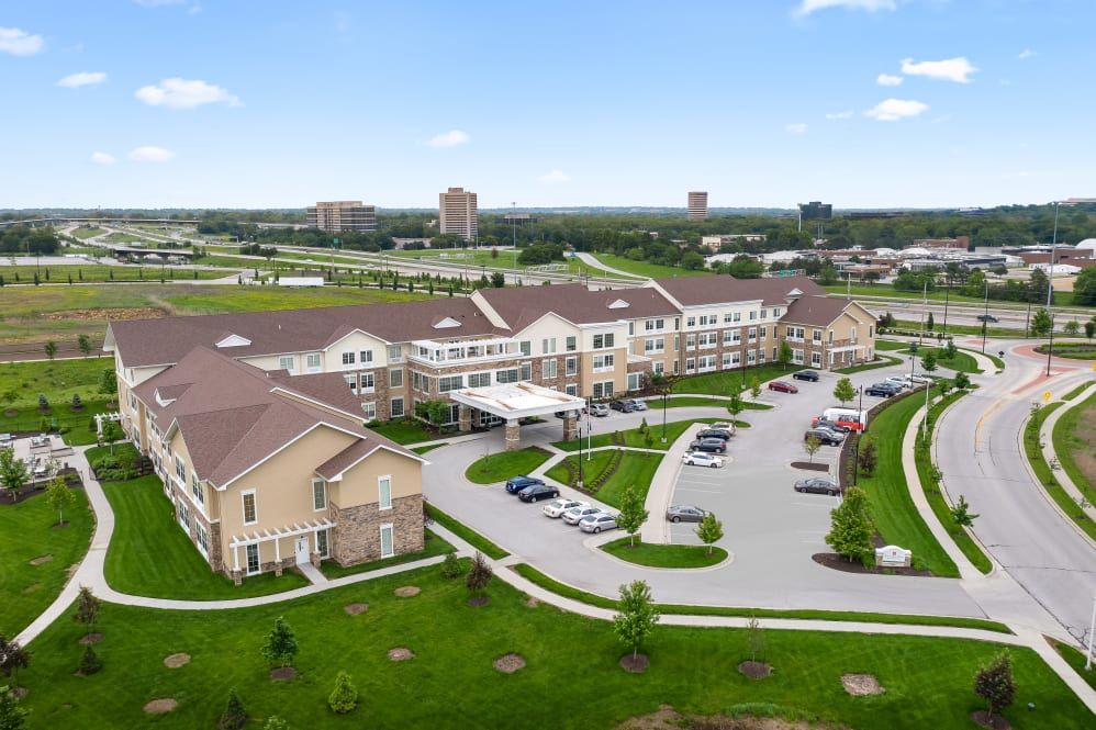 Aerial view of Anthology Of Overland Park senior living community with houses, cars, and driveways.