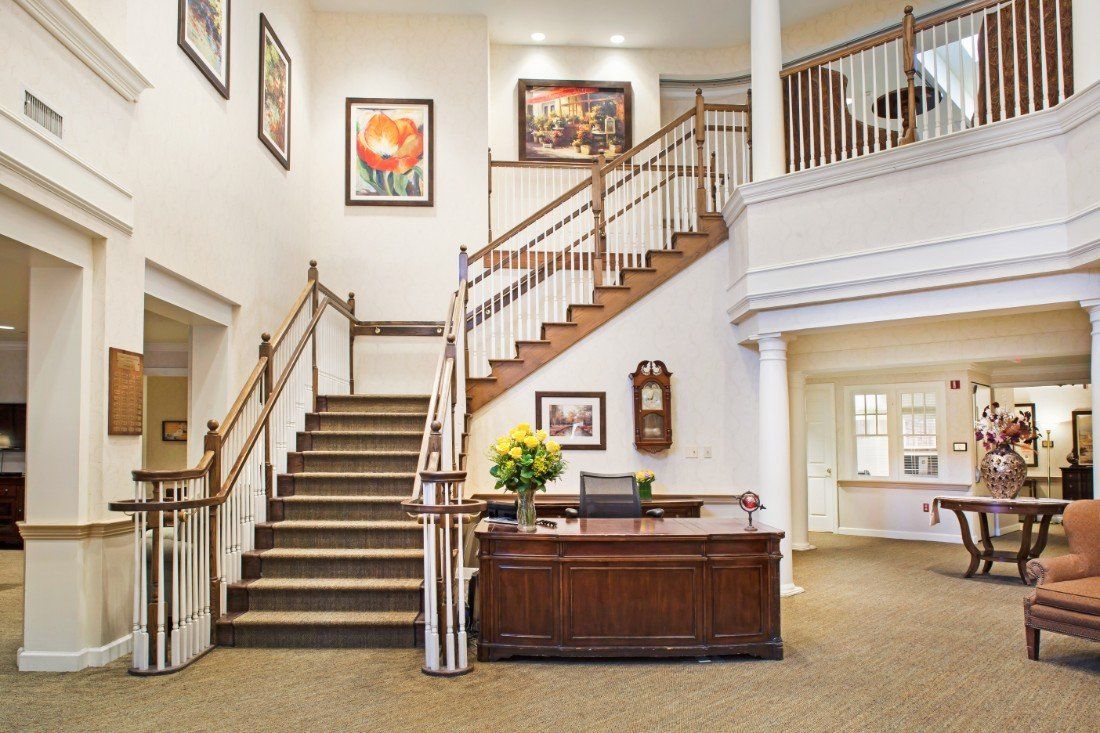 Interior view of Sunrise of Westfield senior living community featuring art-filled foyer and staircase.