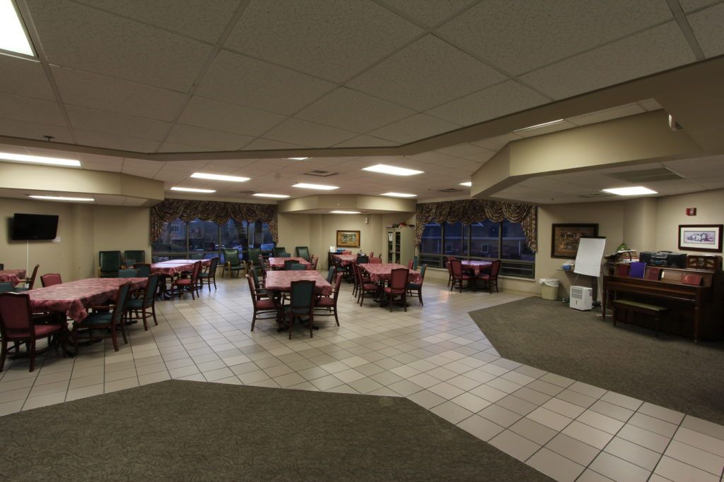 Interior view of Claiborne Health and Rehabilitation Center featuring dining area, lounge, and library.