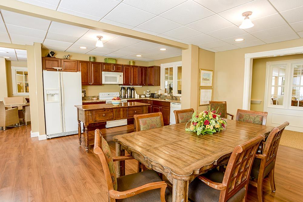 Interior view of Greystone Farm at Salem senior living community featuring a well-furnished dining room and kitchen.