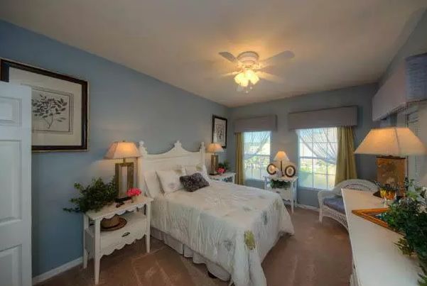 Interior view of a furnished bedroom at Aston Gardens At Pelican Pointe senior living community.
