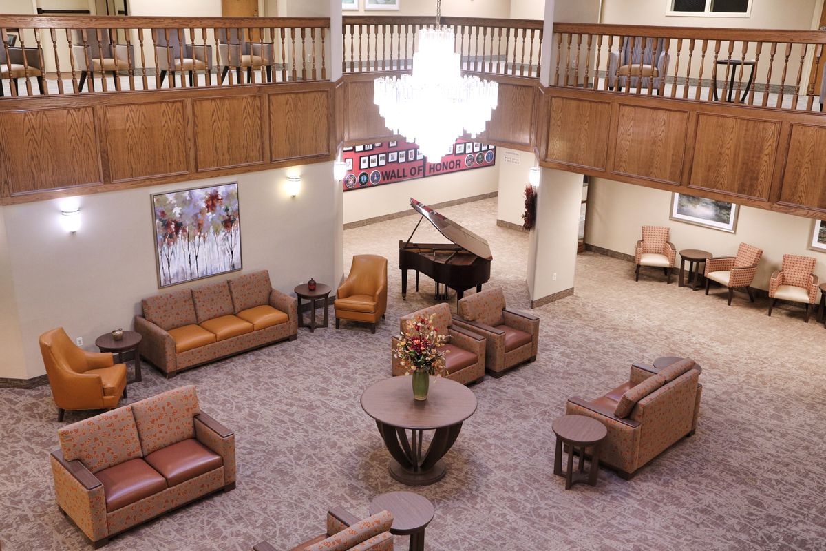 Interior view of Heritage Oaks senior living community featuring piano, elegant furniture, and art.