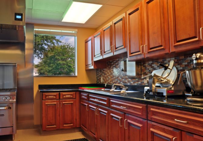 Interior view of Memory Lane Cottage at Tampa Palms featuring a well-designed kitchen with wooden cabinets and modern appliances.