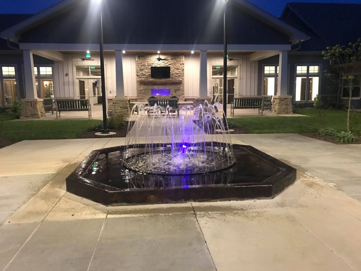 Senior living community, Springhouse Village East, featuring architecture, fountain, and outdoor nature.