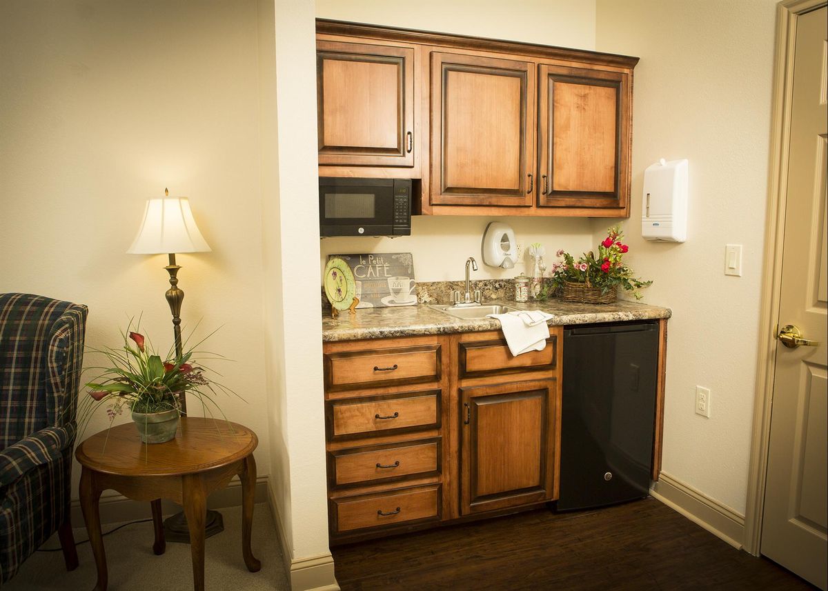 Interior view of The Gardens At Barry Road Assisted Living, featuring kitchen appliances and decor.