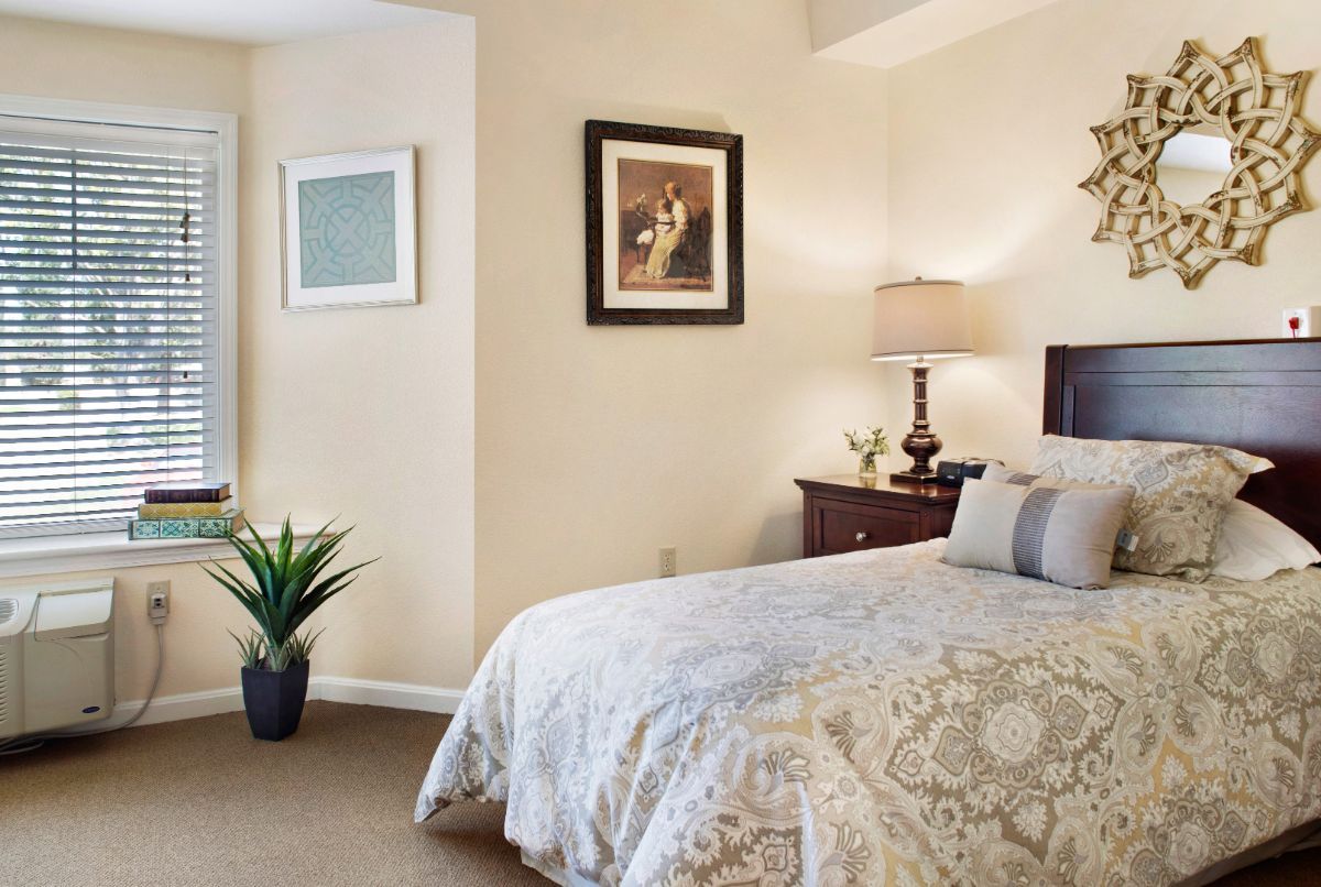 Senior living room interior at Canyon Crest with bed, furniture, plants, and decor.