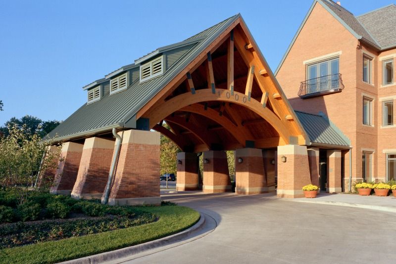 Senior living community, The Garlands of Barrington, featuring Gothic arch architecture, indoor garage, and lush greenery.