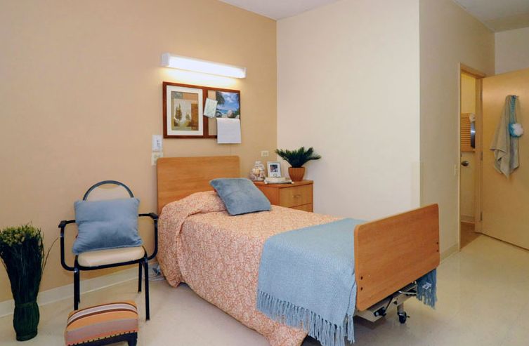 Senior living bedroom interior at Wentworth Rehab & Health Care Center with cozy decor.