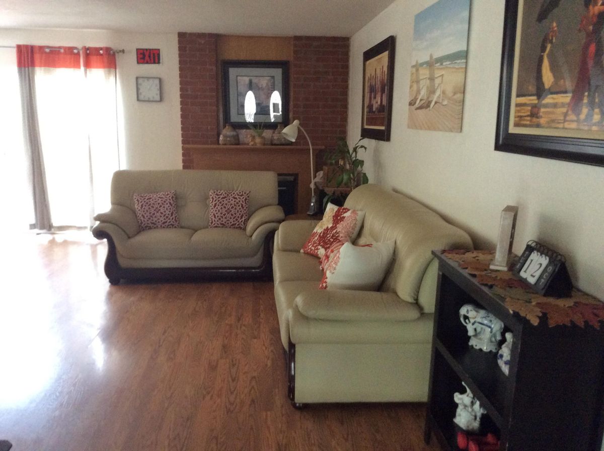 Senior living room interior at Isherwood Care III with hardwood flooring, art, and decor.